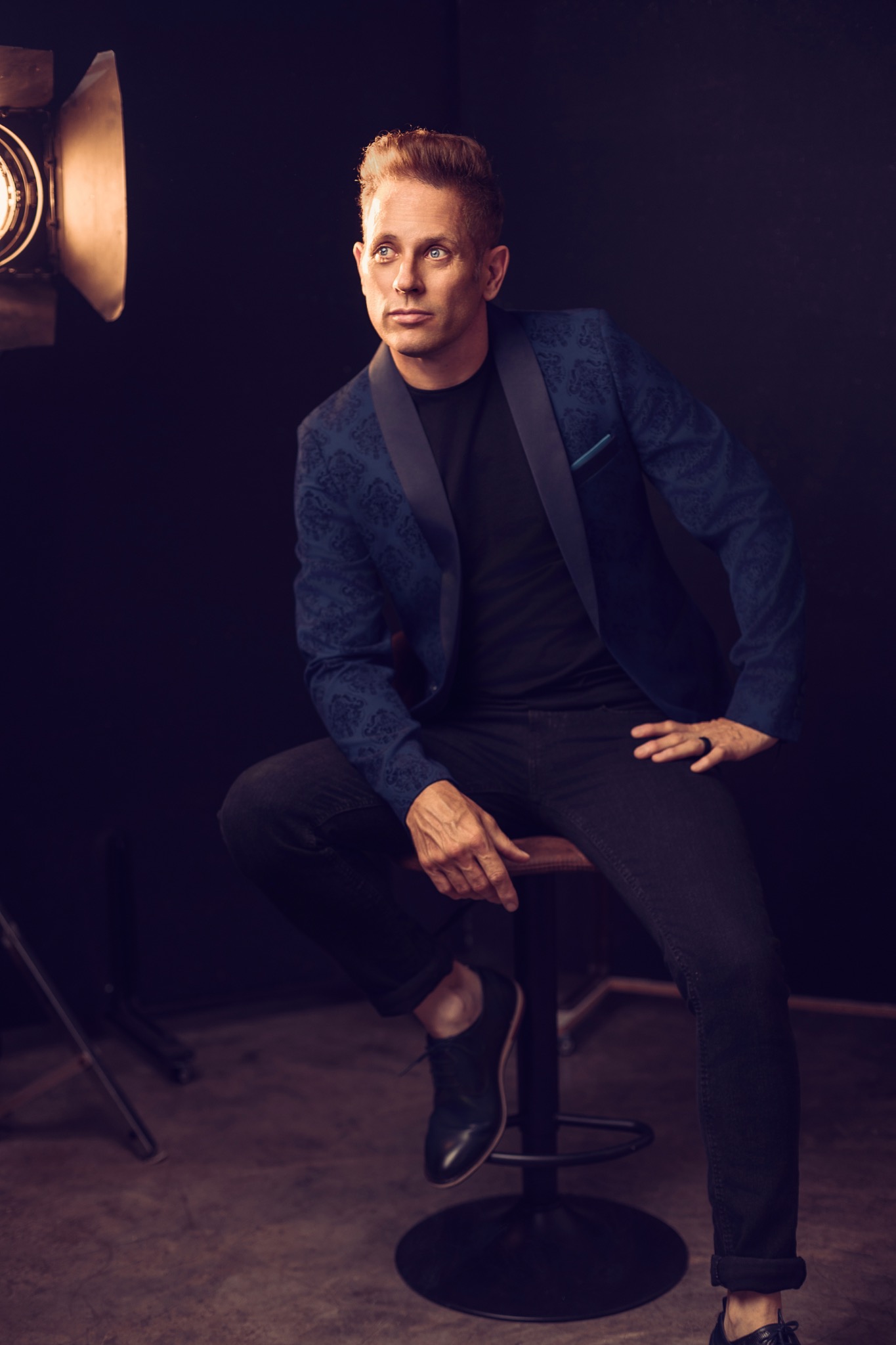 Garth Taylor seated beside a studio light